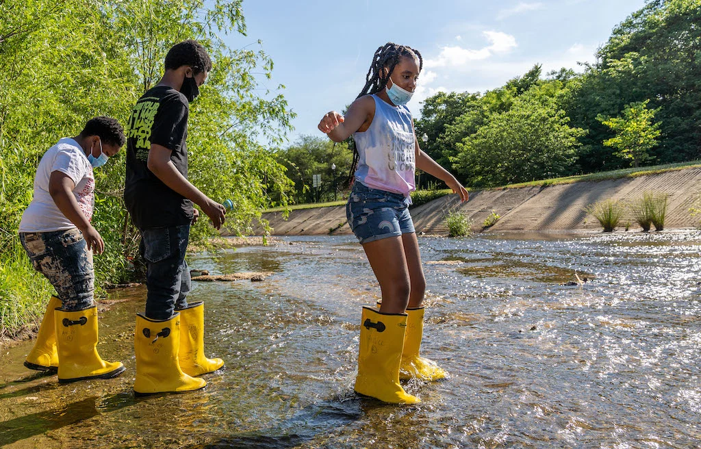 booted children treading carefully in the stream