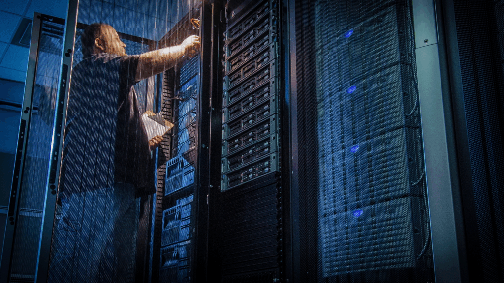 Man monitoring a bank of servers in a data center